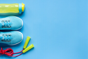 Flat lay of fitness gym equipment with sneakers and bottle of water
