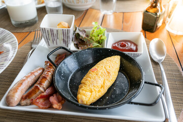 Classic western breakfast plate with omelette, sausages and bacons.