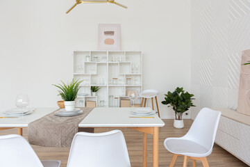 interior design spacious bright studio apartment in Scandinavian style and warm pastel white and beige colors. trendy furniture in the living area and modern details in the kitchen area.