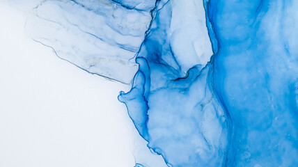 Blue alcohol stains of paint with the addition of gold powder. Subtle waves of paint, abstract blue...