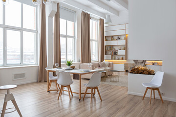 interior design spacious bright studio apartment in Scandinavian style and warm pastel white and beige colors. trendy furniture in the living area and modern details in the kitchen area. - obrazy, fototapety, plakaty