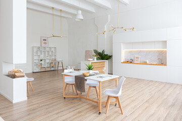 interior design spacious bright studio apartment in Scandinavian style and warm pastel white and beige colors. trendy furniture in the living area and modern details in the kitchen area.