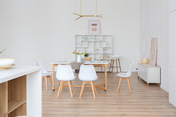 interior design spacious bright studio apartment in Scandinavian style and warm pastel white and beige colors. trendy furniture in the living area and modern details in the kitchen area.