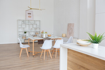 interior design spacious bright studio apartment in Scandinavian style and warm pastel white and beige colors. trendy furniture in the living area and modern details in the kitchen area.