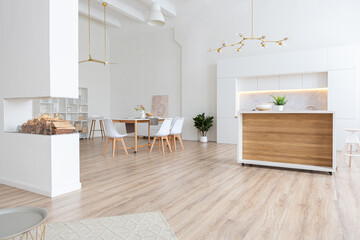 interior design spacious bright studio apartment in Scandinavian style and warm pastel white and beige colors. trendy furniture in the living area and modern details in the kitchen area.