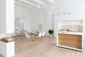 interior design spacious bright studio apartment in Scandinavian style and warm pastel white and beige colors. trendy furniture in the living area and modern details in the kitchen area.