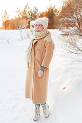 Cheerful girl in warm clothes walking outdoors near the beautiful forest
