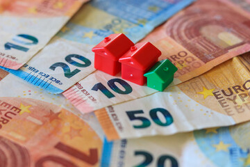 table covered with Euro banknotes with houses on top. Real estate investment concept	