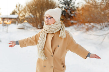 Cheerful girl in warm clothes walking outdoors near the beautiful forest