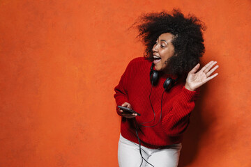 Excited african american girl using cellphone and waving hand