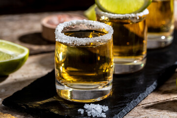 Mexican tequila with lime and salt on rustic black background. space for text. luxury drink. Alcoholic drink concept