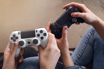Female hands hold game joysticks, women play computer games