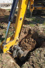 excavator on a construction site digs ditches, the process of work close up.