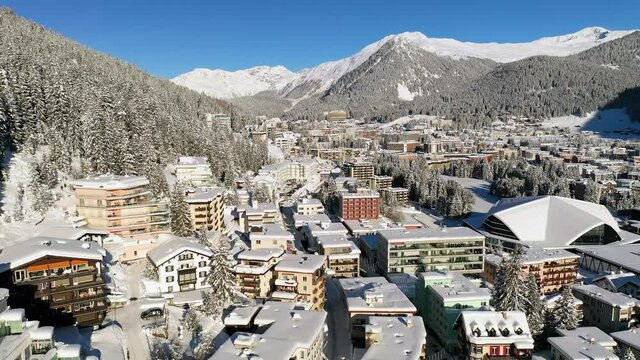Davos, Switzerland: Aerial view of famous Swiss Alpine ski resort town in winter, buildings and slopes covered in snow - landscape panorama of Alps mountain range from above, Europe