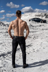 Sexy muscular man isolated on white quarry background. Athletic back of unrecognizible sportsman. Closeup.