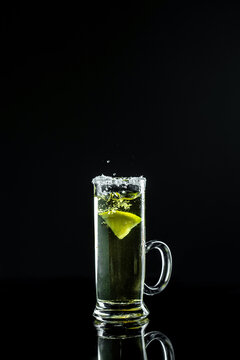 Mexican tequila with lime and salt on black background. space for text. concept luxury drink. Alcoholic drink. Freeze motion, drops in liquid splash. vertical image