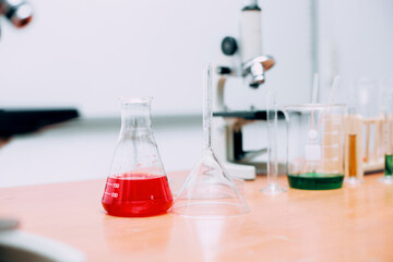 Red liquid on beaker with lab equipment on the table