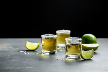 shots of Mexican Gold Tequila with lime and salt on stone background. concept luxury drink. Alcoholic drink. place for text