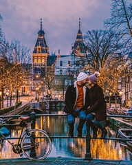 couple men and woman mid age on city trip Amsterdam, couple in the evening by the canals of...
