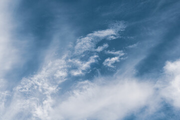 Reflections warm rays setting sun, swirls strong gust wind, outdoors. Bright blue sky, white translucent feathery clouds. Horizontal photography
