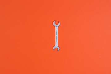 Wrench on an orange background, top view, construction worker, construction tool. home renovation, apartment renovation, builder tool.
