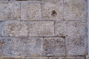 Background well-hewn stones different sizes, smooth surface old wall, close-up vintage texture background, grungy building facade.