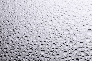 Water droplets on the acrylic surface in gradient gray colors.
