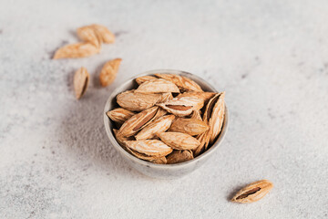 Pile of Almond nuts in a bowl on a white background