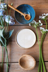 Porcelain set on a wooden table. Wooden spoon in a blue plate. Blue and white plates with flowers