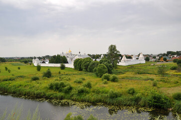 Panoramic view of the Holy Intercession Monastery. River and field. July 08, 2019, Suzdal, Russia.