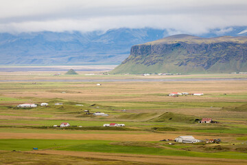 Fototapeta na wymiar View of the Icelandic countryside with their farms at the base of the mountains.