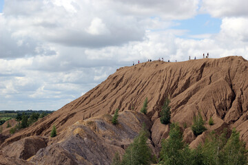 Fototapeta premium A hill with people on top. Tourists visit natural attractions.