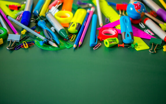 A set of stationery on the background of the chalk board. Back to school concept banner. A large number of pencils, rulers, clips, markers, creatively decomposed with copy space for text.