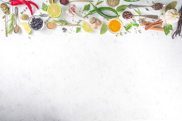 Fresh herbs, dried colorful spices. Cooking background flatlay with variety spices, herbs pepper, vanilla bean, cinnamon, basil, rosemary, chilli red green peppers, mint, parsley White table top view