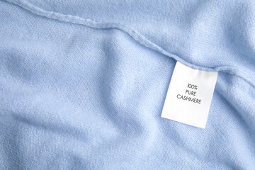 Warm light blue cashmere sweater with label, closeup