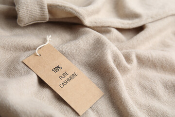 Warm beige cashmere sweater with label, closeup