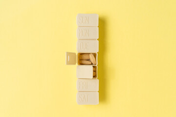 Medicine tablet container on yellow background. Daily eating concept of taking medicine.