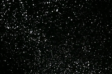 It snows at night in a ray of light.