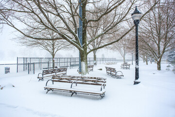 Park benches in a snowstorm at Scenic Hudson Park in Irvington, NY