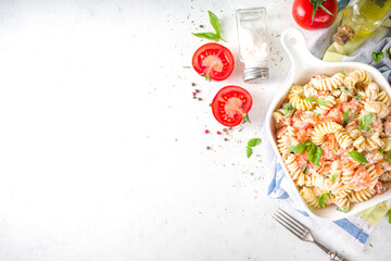 Spring diet healthy vegan pasta. Italian fusilli pasta with tomatoes, green vegetables, fresh herbs, cream cheese or feta, on dark table background copy space