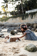 Seasonal photography of journay. Little girl with her lovely pet relaxes on seacoast on her holidays. Portrait of a girl and her dog in background of nature landscape.