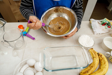 Batiendo mezcla de ingredientes para hornear un panque de plátano. Concepto de repostería en casa