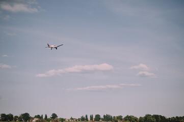 small plane flies in the sky, clouds, field