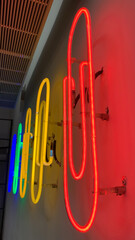 Multi color office clip shaped neon lights installed on white wall
