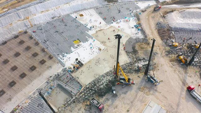 Equipment for installing piles in ground, heavy machines for driving pillars work in laying the foundation building. Construction aerial view height