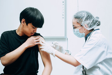 Young patient when being in vaccine injection by the doctor, vaccination coronavirus campaign....