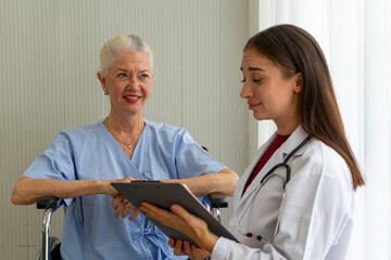 Obraz premium Caucasian old senior depressed upset woman patient on wheelchair talking to medical doctor with stethoscope in hospital 