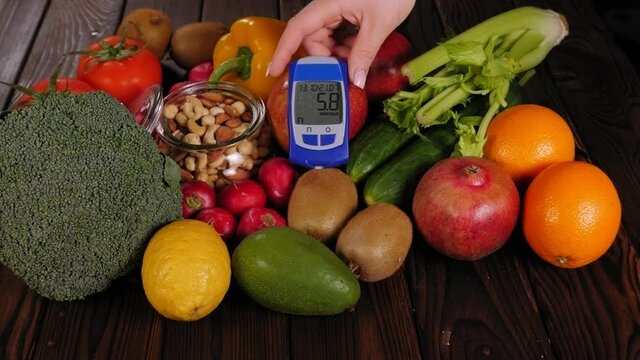 Lots of vegetables and fruits and a blood sugar meter on a wooden background. Diabetes diet. Healthy lifestyle.