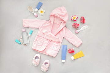 Obraz na płótnie Canvas A set of baby things for swimming. Pink terry robe and slippers for the baby. Children's cosmetics and care.