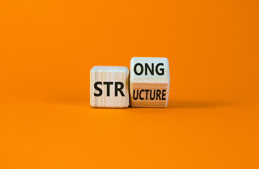 Strong structure symbol. Turned a wooden cube with words 'strong structure'. Beautiful orange background, copy space. Business and strong structure concept.